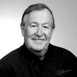 Tracy Doriot_Owner 250x250web2019 Tracy Doriot is a boomer aged male wearing a black button up logoed shirt with a soft smile and hair parted to the side.